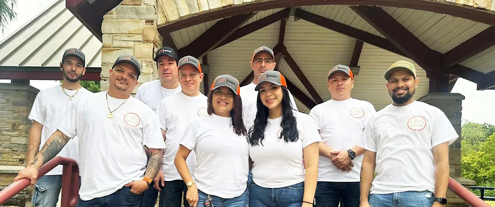 Professional food industry team members in matching white branded shirts at outdoor team event, representing foodservice supplier or distributor workforce.