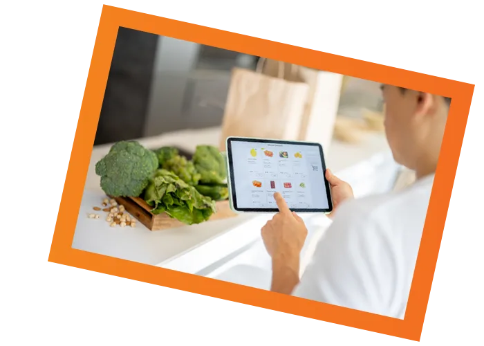 Person using a tablet for meal planning in a modern kitchen with fresh produce.